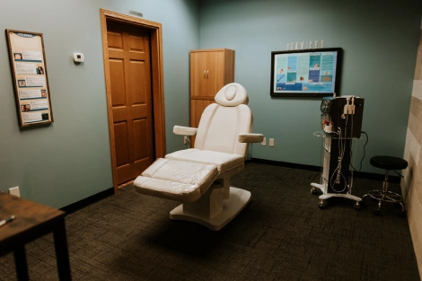 treatment room at Lotus Laser Aesthetics featuring a laser chair and professional skincare equipment.